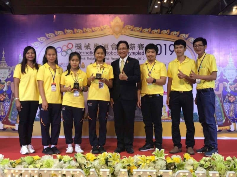 ตัวแทนนักเรียนหญิงรับรางวัลถ่ายรูปร่วมกับผู้บริหารบนเวทีการแข่งขัน